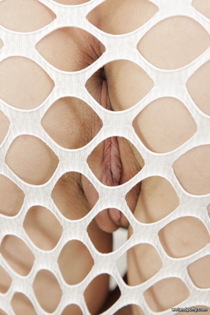 Худощавая брюнетка в сетчатом платье мастурбирует кистью на диване - секс порно фото